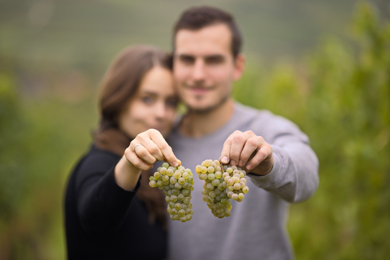Lena und Sebastian im Weinberg mit Trauben in der Hand